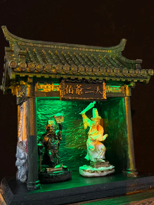 Side angle view of a miniature car shrine temple model featuring Tua Di Ya Pek, showing depth and green-lit interior