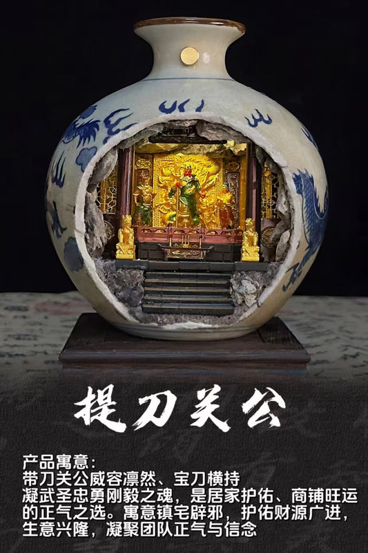 Promotional product shot of a blue and white porcelain vase with a cave cutout revealing an illuminated miniature shrine diorama of Guan Di Sheng Jun (关帝圣君) standing with a blade, flanked by gold guardians on a wooden stand, with Chinese text overlay reading 提刀关公 on a dark background