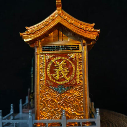 Close-up of the right side panel of a custom miniature car shrine model against a black background, featuring a gold embossed 义 character in a circular frame on a red panel with gold cloud carvings below and pagoda roof corner visible above